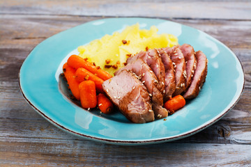 Roast veal with mashed potatoes garnish on blue plate. Copy space