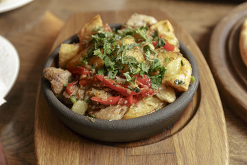 Restaurant Shot. Meat in a hot pan, baked with potatoes and vegetables. Caucasian kitchen.