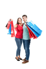Full body of attractive couple smiling carrying shopping bags