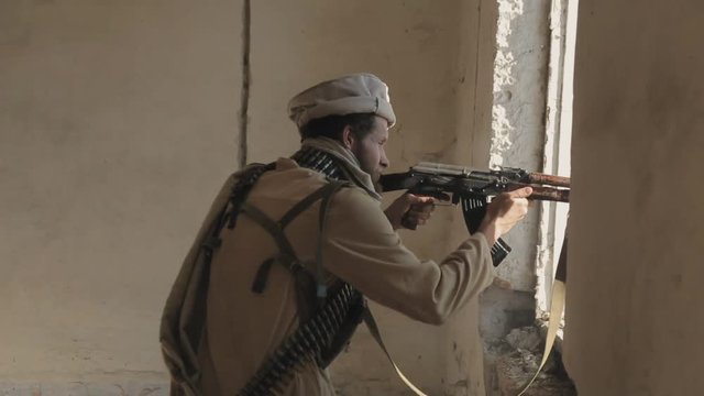 Armed man with the clip over clothes fires his rifle