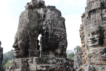 Fototapeta premium The ruins of an old temple with stone heads and faces in Cambodia