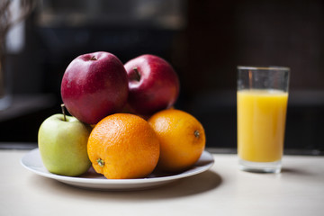 Fruits with orange juice in glass on the table.