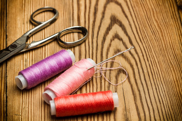 Fototapeta na wymiar Hilos de colores, tijera y aguja de coser