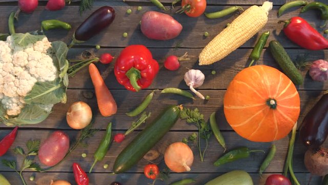 Vegetable mix on the table.

Top view. Close up. The smooth glide of the camera ( from left to right ) along the old village table with a variety of vegetables.