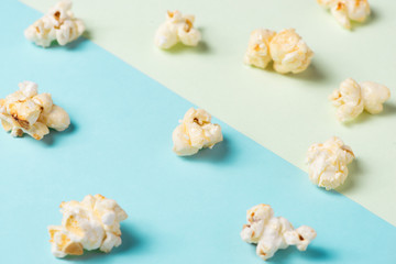 The popcorn in paper cup on green and blue background.