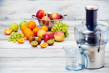 Modern electric juicer and various fruit on kitchen counter, healthy lifestyle detox concept - obrazy, fototapety, plakaty