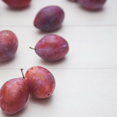 Red plum on a white table.