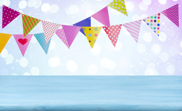 Birthday concept with wooden table, garlands and abstract lights background