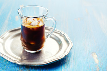 Refreshing iced coffee with cream over blue summer background