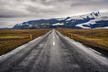 Road No. 1 in Iceland, asphalt and mountains with a glacier in the background.