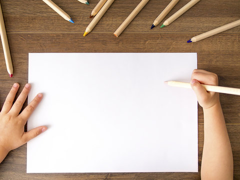 Kid Holding A Pencil Over Empty White Sheet Of Paper