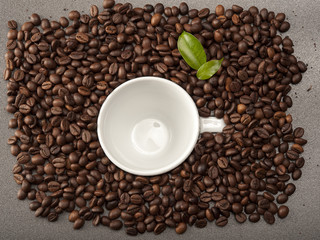 Coffee beans allover white cup of coffee beans