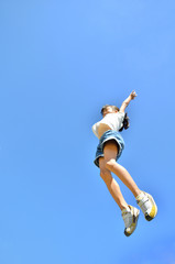 Fototapeta na wymiar 青空でジャンプする女の子