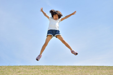 青空でジャンプする女の子