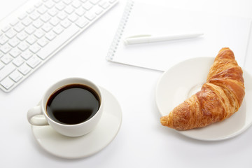 Keyboard, blank notebook with pen, croissant and cup of coffee on white background