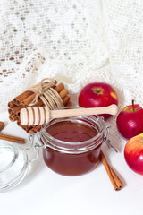 Honey and apples and cinnamon on wooden table
