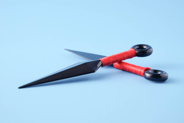 To throw ninja weapons isolated on blue paper background