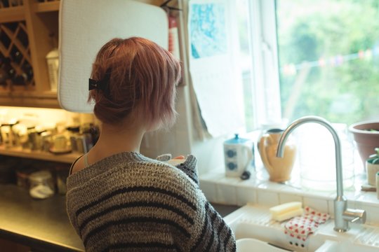 Rear view of woman standing in kitchen