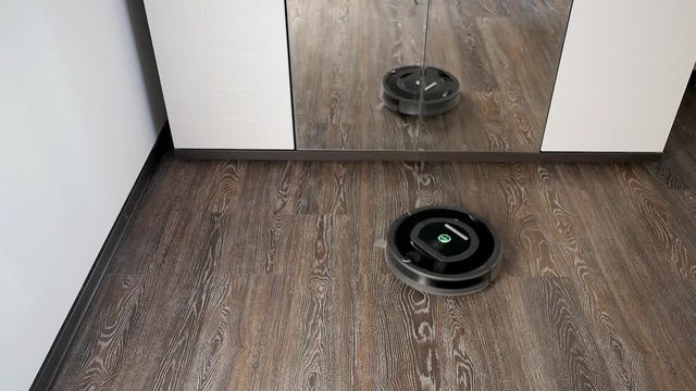 Robot vacuum cleaner is cleaning in a furnished room
