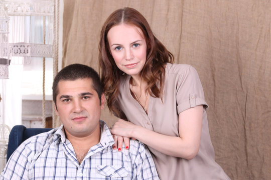Pretty caucasian woman and man in shirt pose together in studio