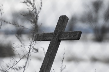 Black and white cross made of wood in nature