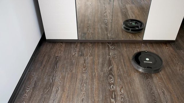 The robot vacuum cleaner removes the floor covered with a laminate, rotating in a spiral and in an arbitrary route