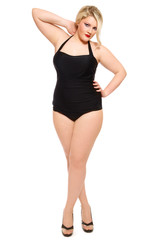 Young beautiful plus-size woman in black old-fashioned swimsuit and stilettos over white background