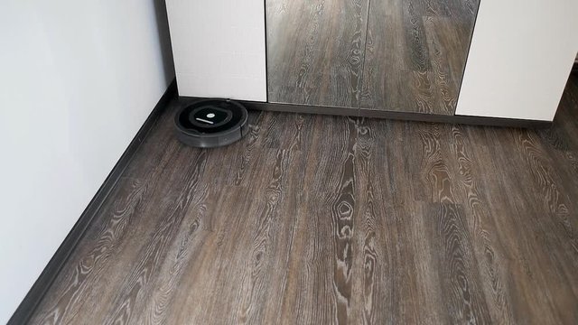 Robot vacuum cleaner is cleaning in a furnished room