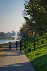Naklejka premium Girls jogging on a path by Ada lake at sunny summer morning in Belgrade, Serbia