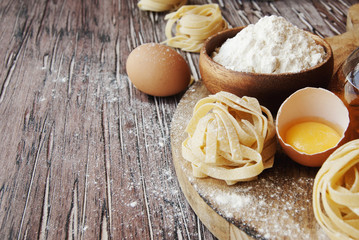 Uncooked pasta with flour on the table, selective focus