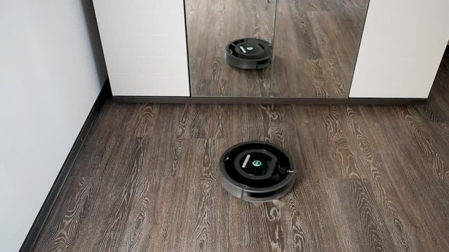 Robot vacuum cleaner is cleaning in a furnished room
