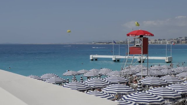 Watchtower for rescue at sea and blue parasols on French riviera beach 