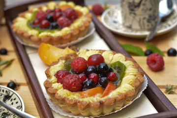 Tasty tart with fresh berries, fruits and cream closeup on tray background