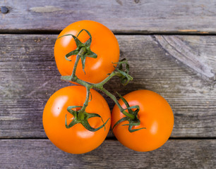 tre orangea tomater mot trä bakgrund