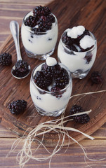 yogurt cup with blackberry on wooden table