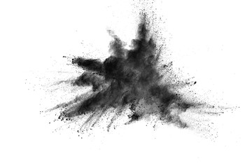 Black powder explosion. Closeup of black dust particles explode isolated on white background.