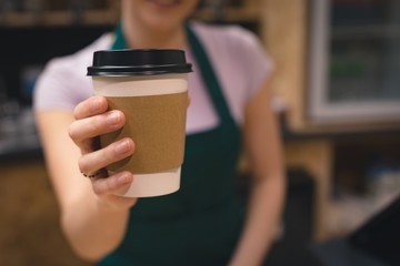 Waitress holding coffee cup in café