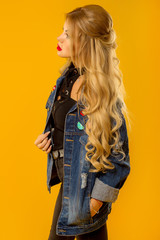 beautiful blonde with long hair in a denim jacket posing