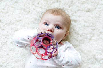 Cute baby girl playing with colorful rattle toy