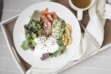 Salmon and eggs breakfast bowl in a comfort zone (couch)