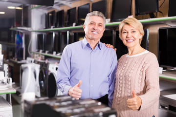 Fototapeta na wymiar Mature couple are happy in household appliances store