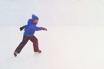 Fototapeta na wymiar little boy skating on ice in winter
