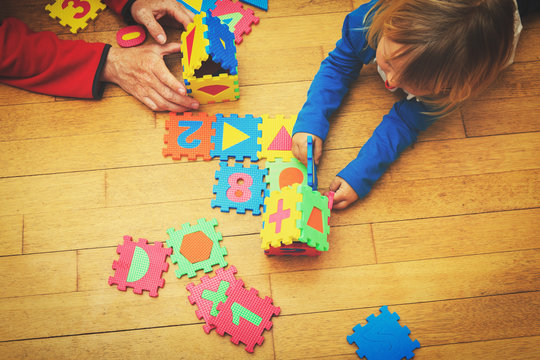 teacher and child playing with puzzle, early education