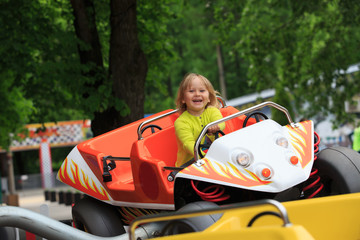 happy little girl on roller coaster ride in amusement park