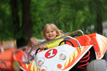 happy little girl on roller coaster ride in amusement park