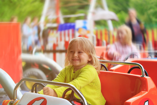 happy little girl on roller coaster ride in amusement park