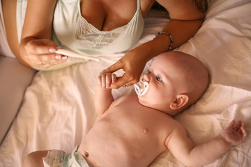 Mother with her little baby boy at home.  Worried mother checks his son's temperature.