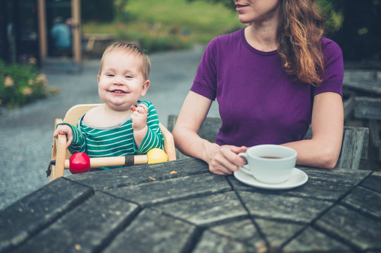 Mother and baby at table outside