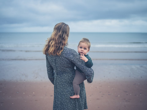 Young mother holding baby by the sea