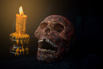Skull and candle in black background.